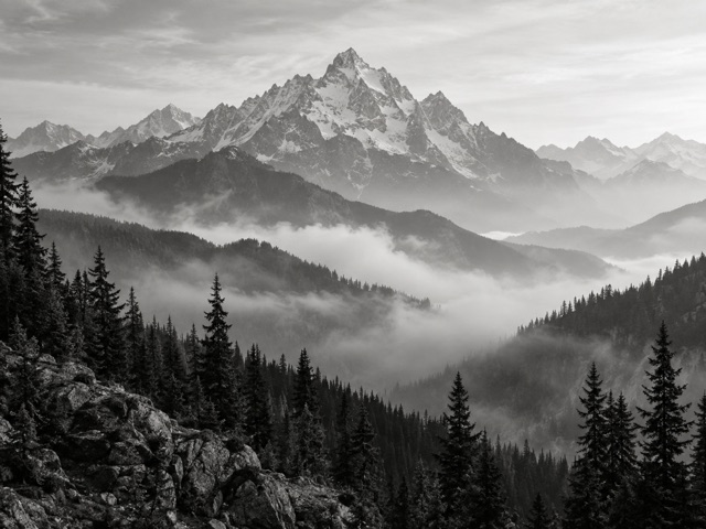 Mountain peaks rising above a misty forest.